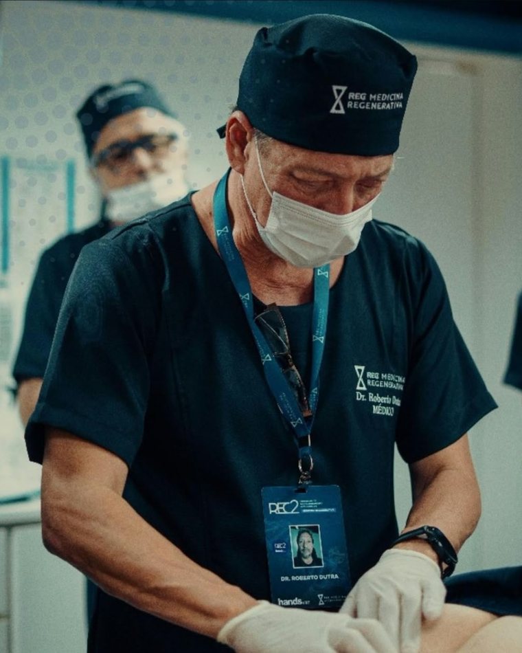 El Dr. Dutra con ambo y guantes realizando un procedimiento regenerativo junto a otros médicos